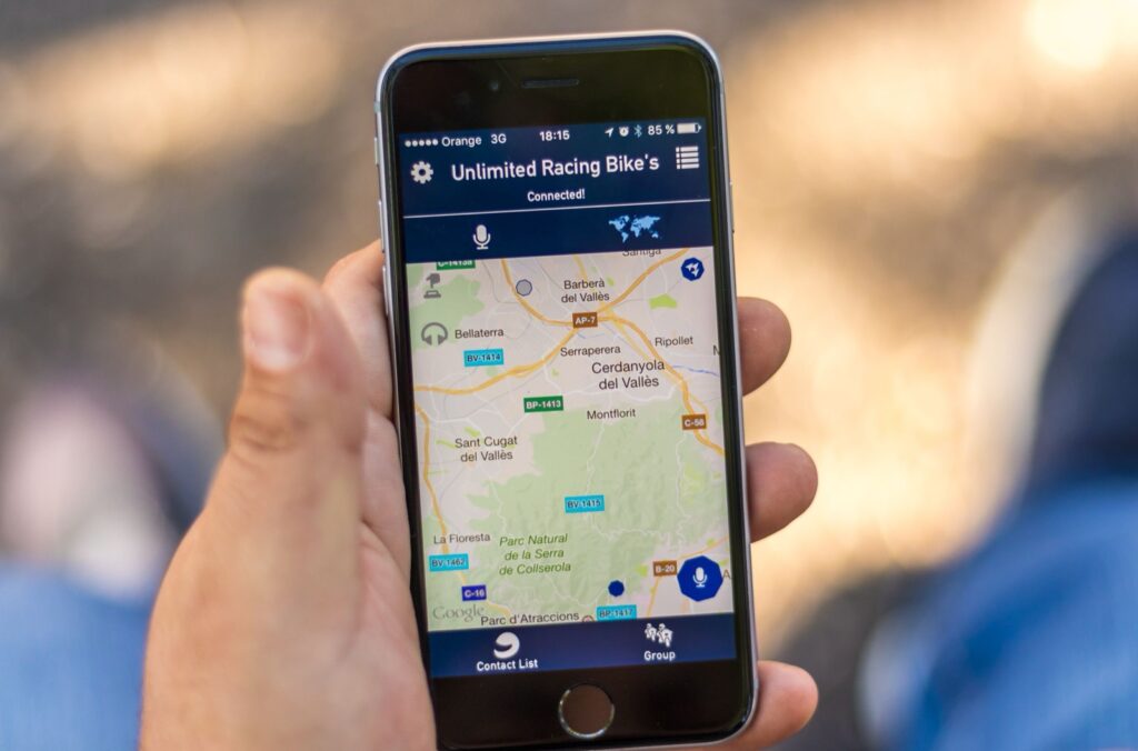 Hand hält ein Smartphone mit einer Kartenansicht in einer App
