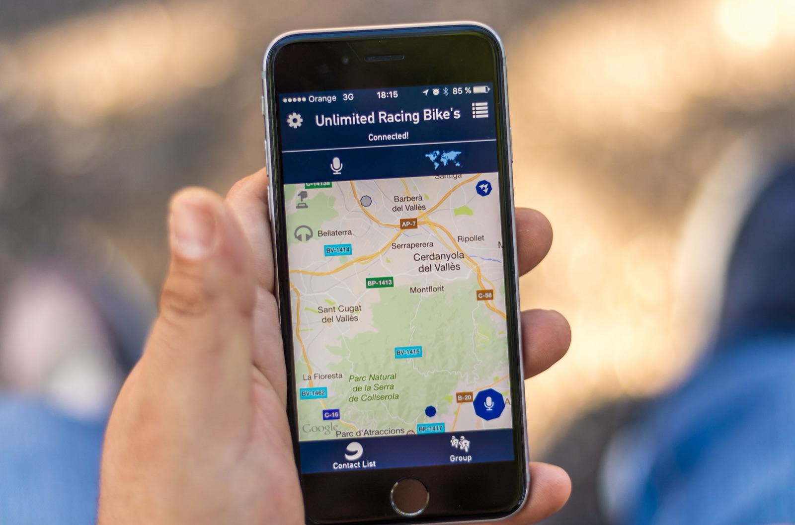 Hand hält ein Smartphone mit einer Kartenansicht in einer App